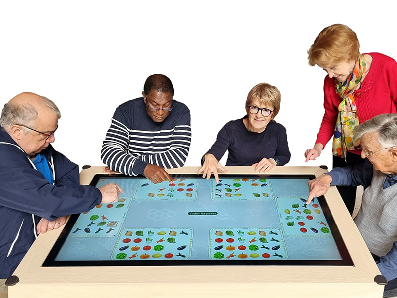 Seniors utilisant la table interactive de mémoire Verdurable lors d'un atelier collectif de stimulation cognitive.